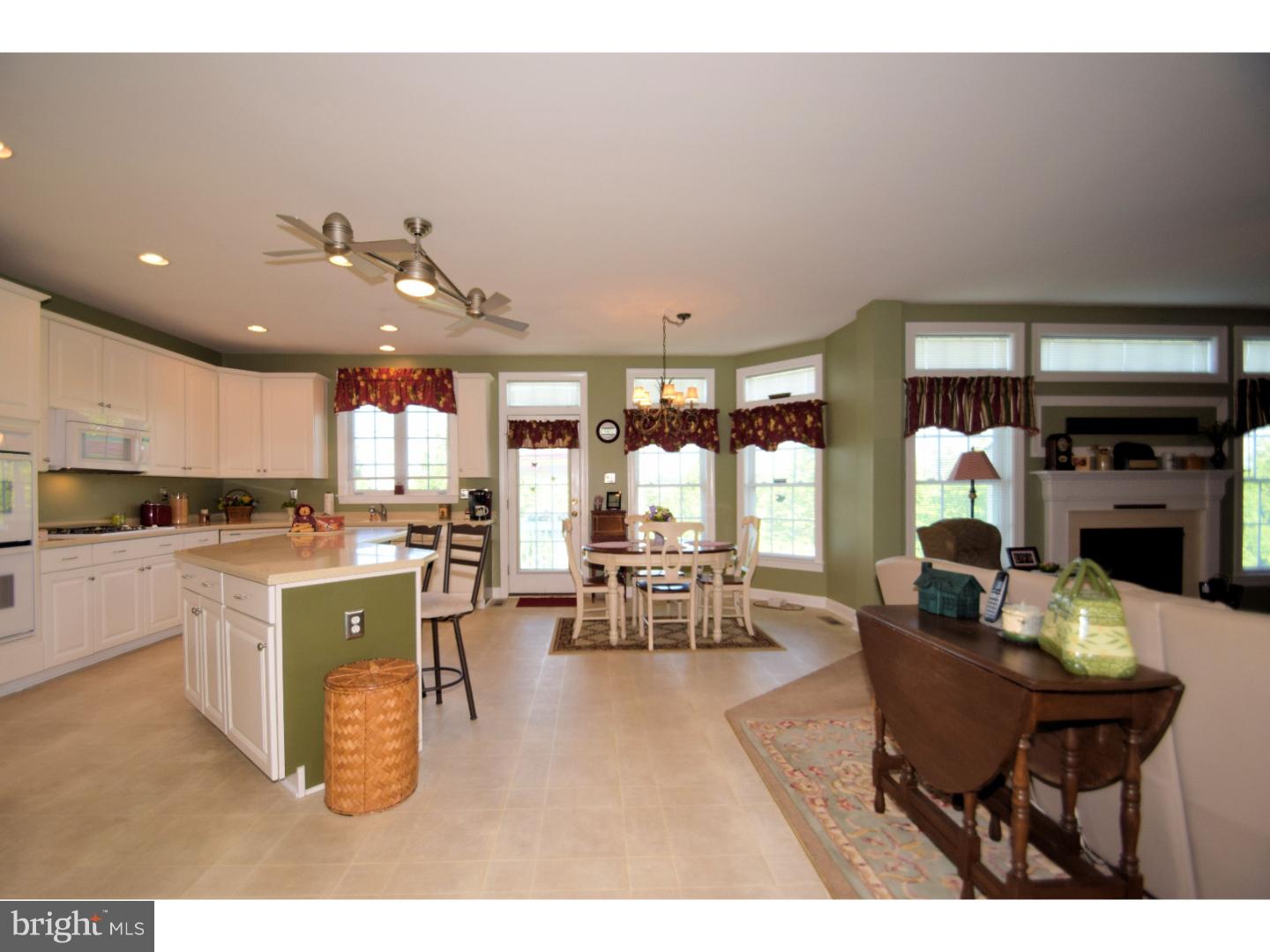 205 Barnhill Road Perkasie, PA 18944 - Photo 8 of 25 a kitchen with a dining table chairs stove and white cabinets