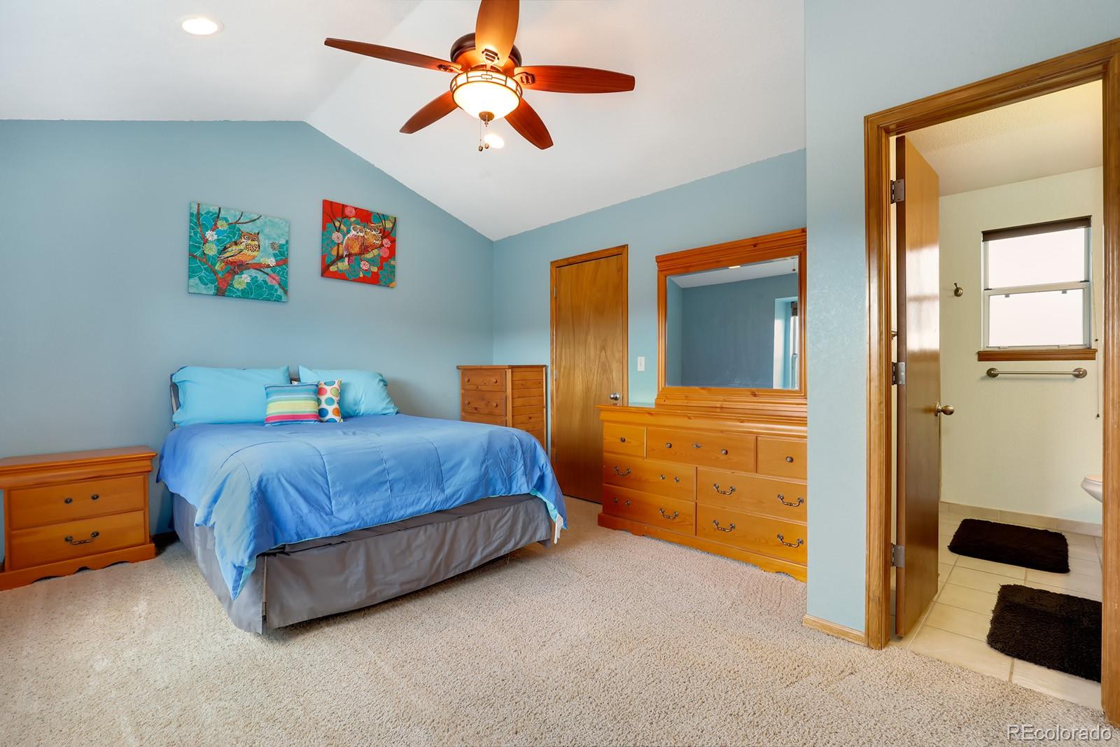 1055 Cobblestone Drive Highlands Ranch, CO 80126 - Photo 12 of 31 a bedroom with a bed and a chandelier