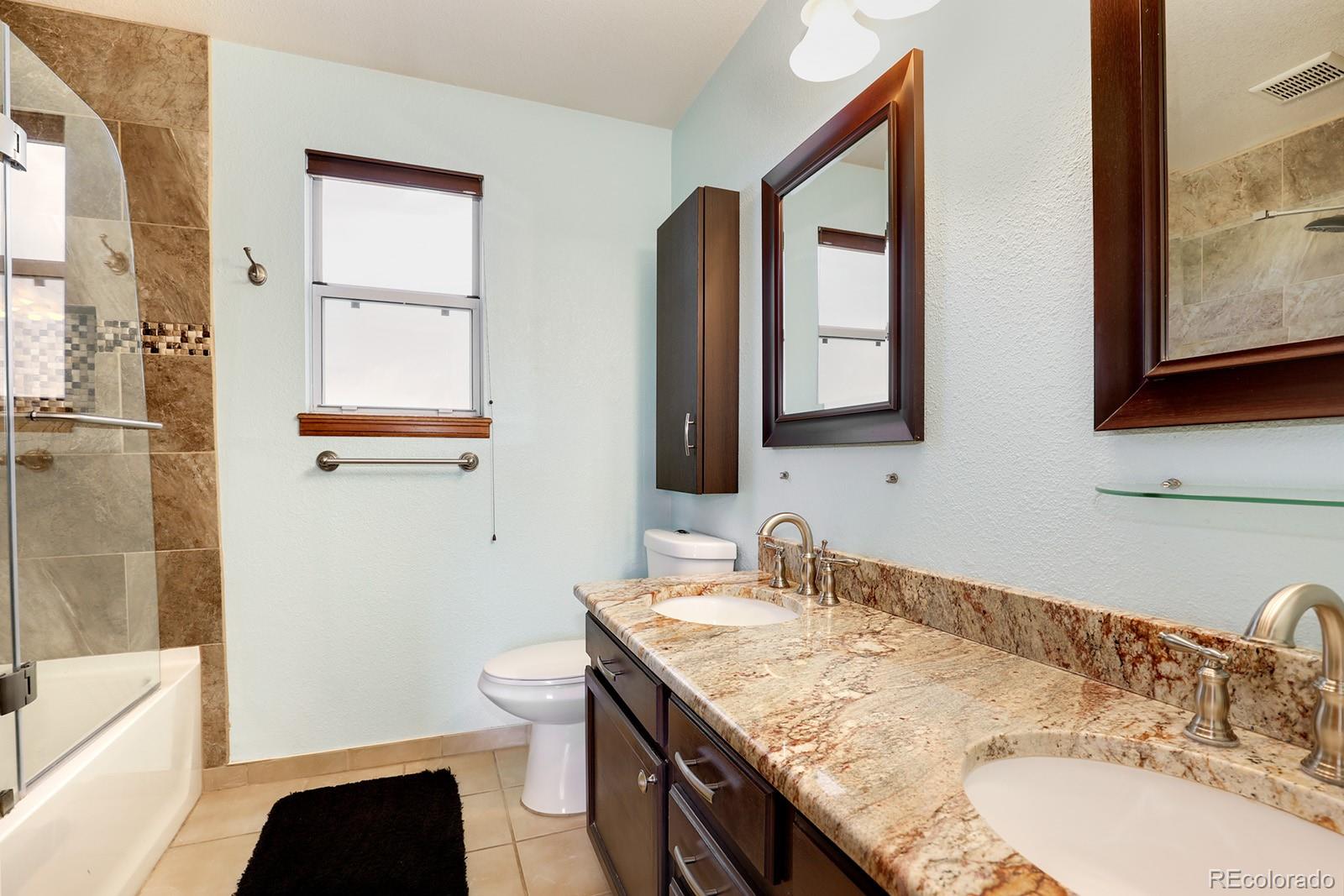 1055 Cobblestone Drive Highlands Ranch, CO 80126 - Photo 14 of 31 a bathroom with a granite countertop sink a toilet and a mirror