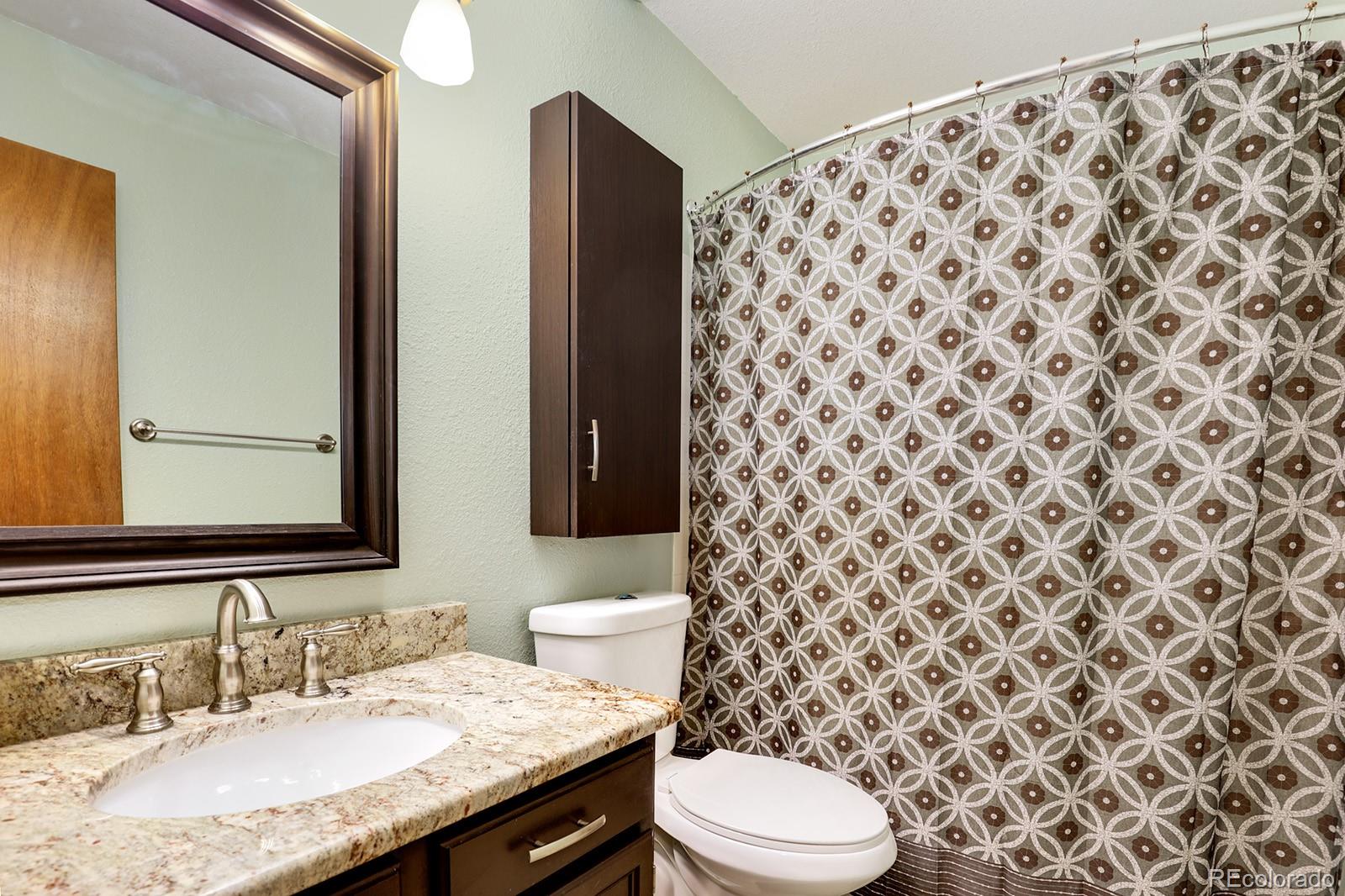 1055 Cobblestone Drive Highlands Ranch, CO 80126 - Photo 15 of 31 a bathroom with a granite countertop toilet and a sink