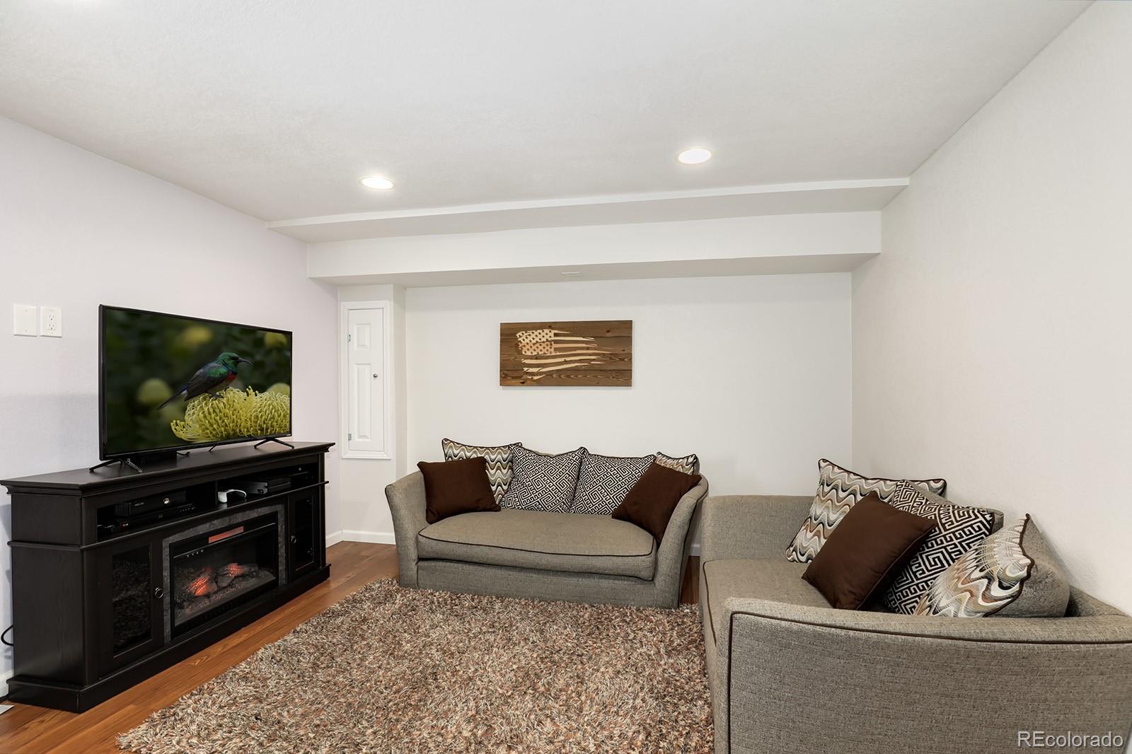 1055 Cobblestone Drive Highlands Ranch, CO 80126 - Photo 20 of 31 a living room with furniture and a flat screen tv