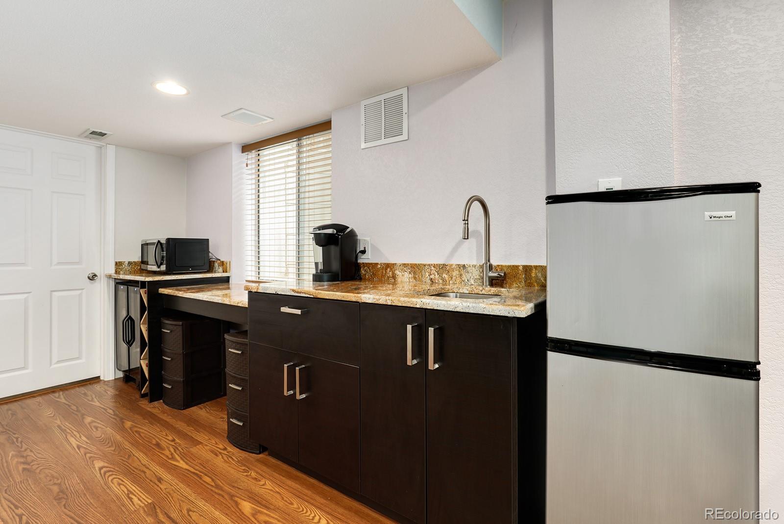 1055 Cobblestone Drive Highlands Ranch, CO 80126 - Photo 22 of 31 a kitchen with a refrigerator and a sink