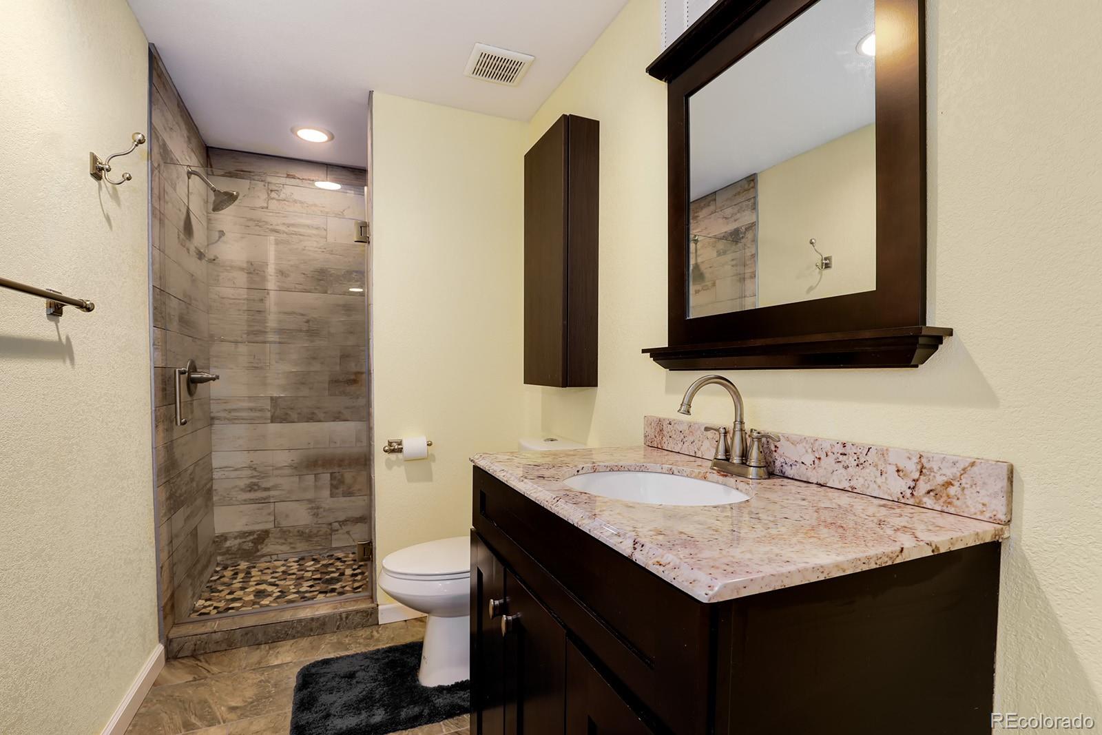 1055 Cobblestone Drive Highlands Ranch, CO 80126 - Photo 26 of 31 a bathroom with a granite countertop sink and a mirror