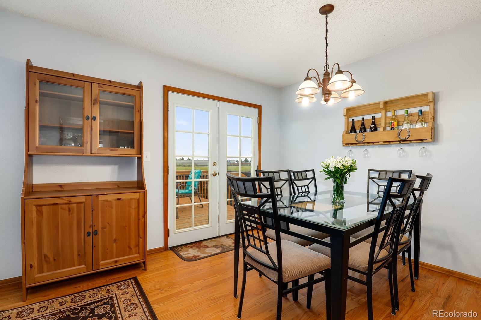1055 Cobblestone Drive Highlands Ranch, CO 80126 - Photo 9 of 31 a view of a dining room with furniture wooden floor and chandelier