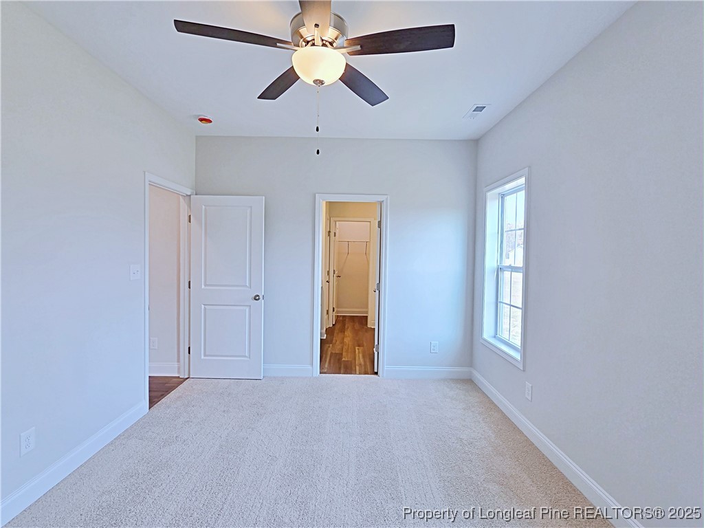 1554 Piney Grove Road Lumberton, NC 28360 - Photo 14 of 27 an empty room with windows and a chandelier fan