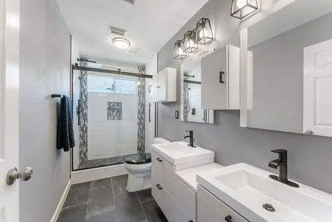 a bathroom with a sink toilet mirror and shower
