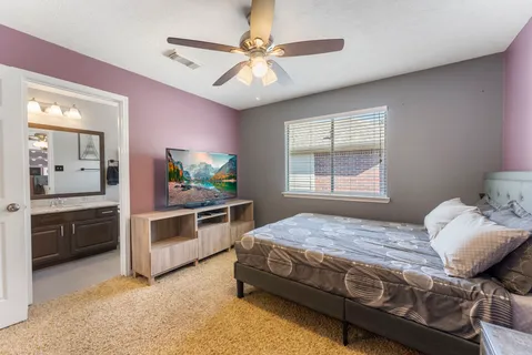 a bedroom with a bed and dresser with mirror