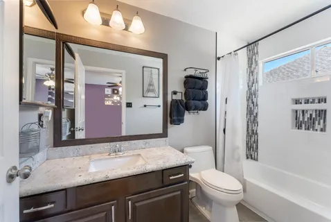 a bathroom with a granite countertop sink toilet and shower