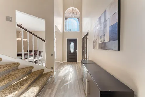 a view of a hallway with wooden floor and a front door
