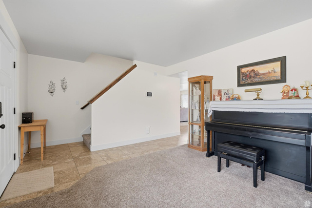 592 West 650 South Springville, UT 84663 - Photo 6 of 33 Entryway featuring a white paneled door, a staircase with wood railing, and a combination of carpet and natural stone-look tile flooring