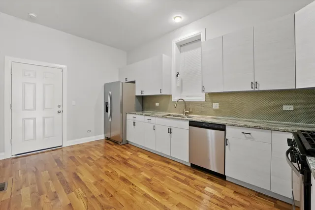 a kitchen with stainless steel appliances granite countertop a stove a sink and a refrigerator