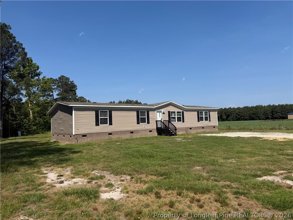 4339 Saddletree Road Lumberton, NC 28360 - Photo 3 of 23 a house that is sitting in the grass with large trees