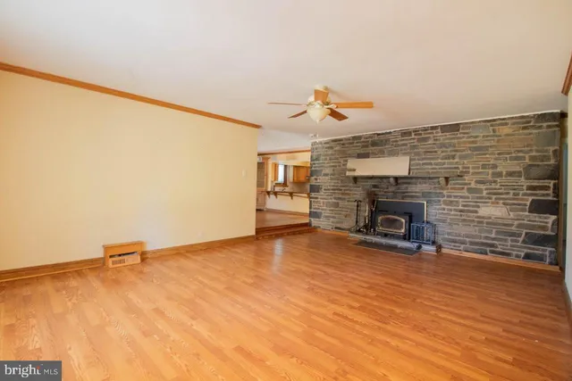a view of empty room with fireplace and wooden floor