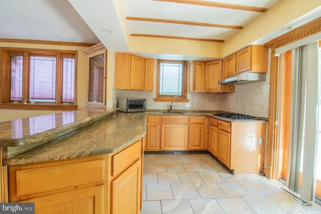 a kitchen with granite countertop a refrigerator and a sink