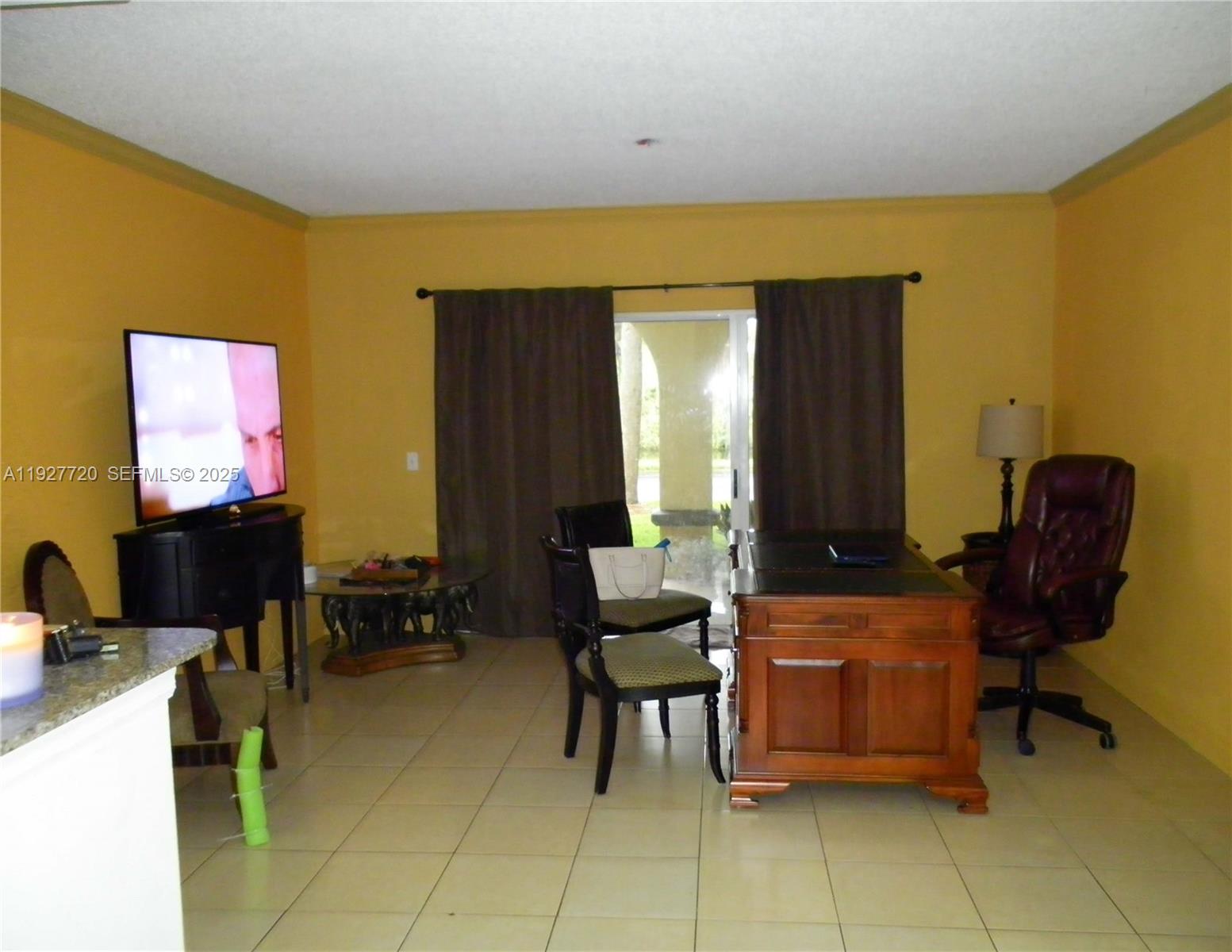 2493 Centergate Drive, Unit 102 Miramar, FL 33025 - Photo 4 of 10 a living room with furniture and a flat screen tv