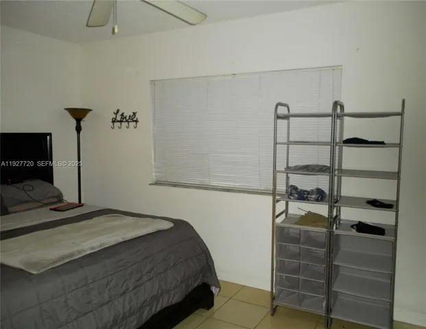 a bedroom with a bed and a flat tv screen on the dresser