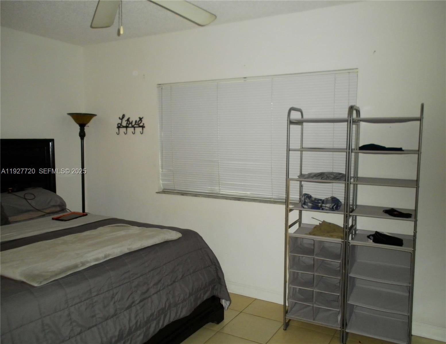 2493 Centergate Drive, Unit 102 Miramar, FL 33025 - Photo 7 of 10 a bedroom with a bed and a flat tv screen on the dresser