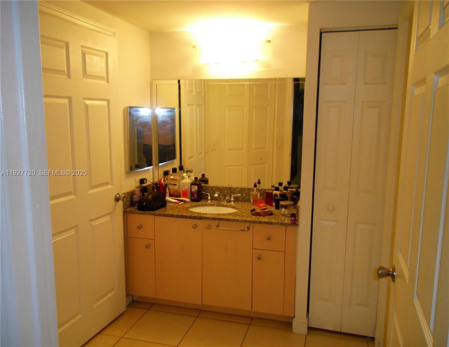2493 Centergate Drive, Unit 102 Miramar, FL 33025 - Photo 8 of 10 a bathroom with a sink and mirror