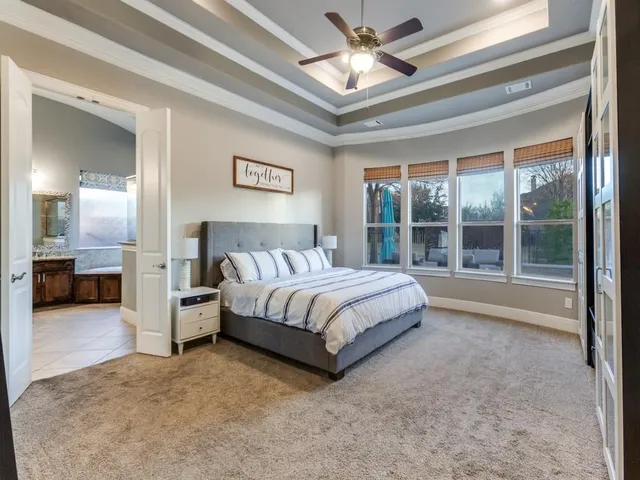 a spacious bedroom with a bed and a large window