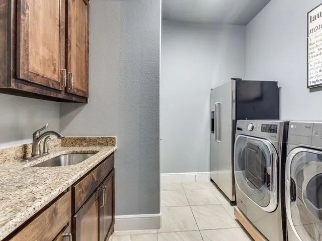 a kitchen with a sink a washer and dryer next to a window