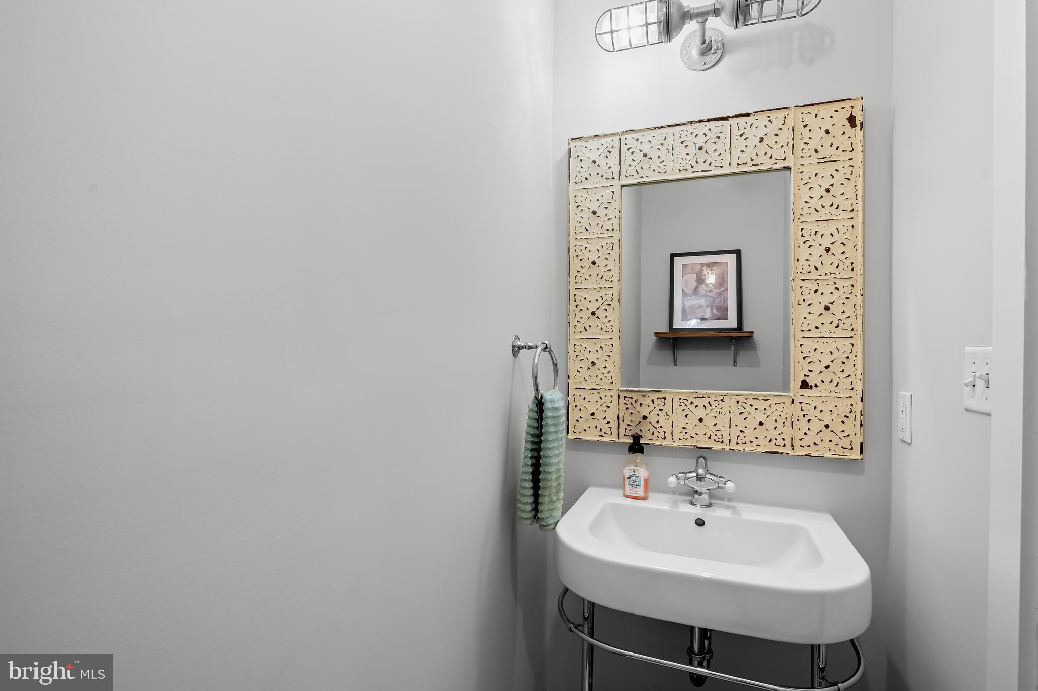 1220 Bank Street, Unit 309 Baltimore, MD 21202 - Photo 25 of 56 a bathroom with a sink and a mirror