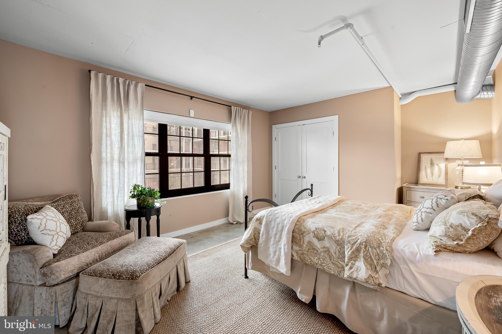 1220 Bank Street, Unit 309 Baltimore, MD 21202 - Photo 28 of 56 a spacious bedroom with a bed a couch and a window