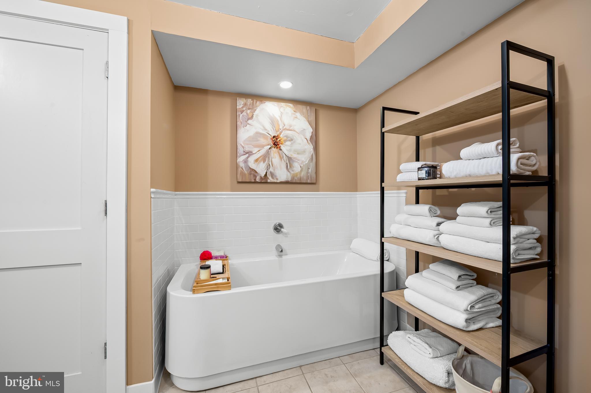 1220 Bank Street, Unit 309 Baltimore, MD 21202 - Photo 38 of 56 a white bath tub sitting next to a bathroom sink