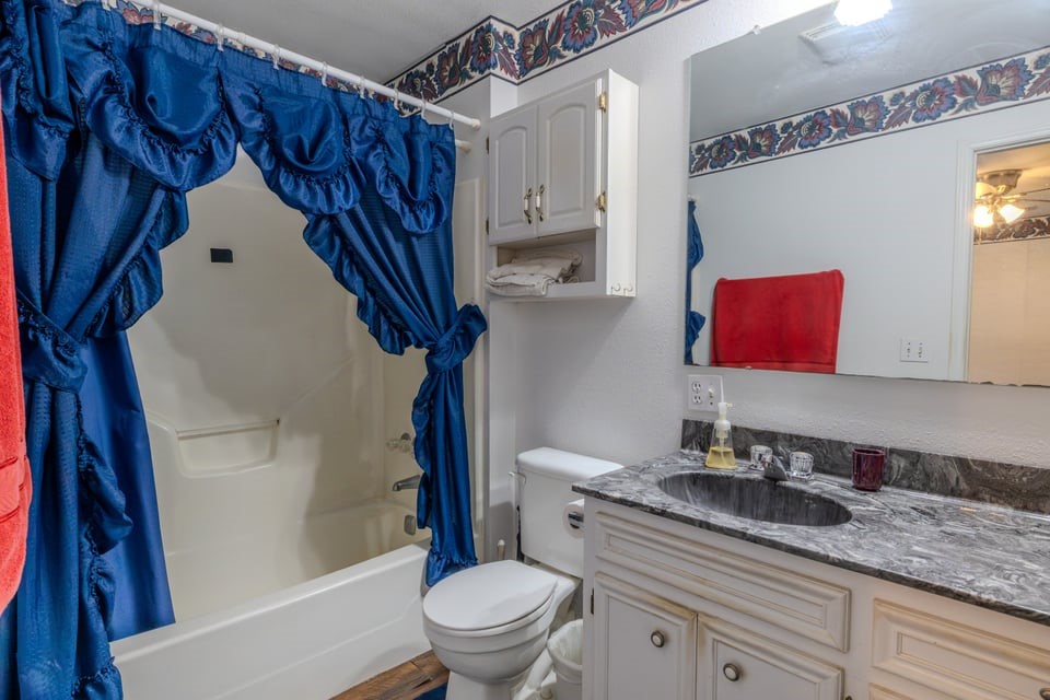 483 Riverside Drive Palacios, TX 77465 - Photo 22 of 41 a bathroom with a granite countertop sink toilet and shower