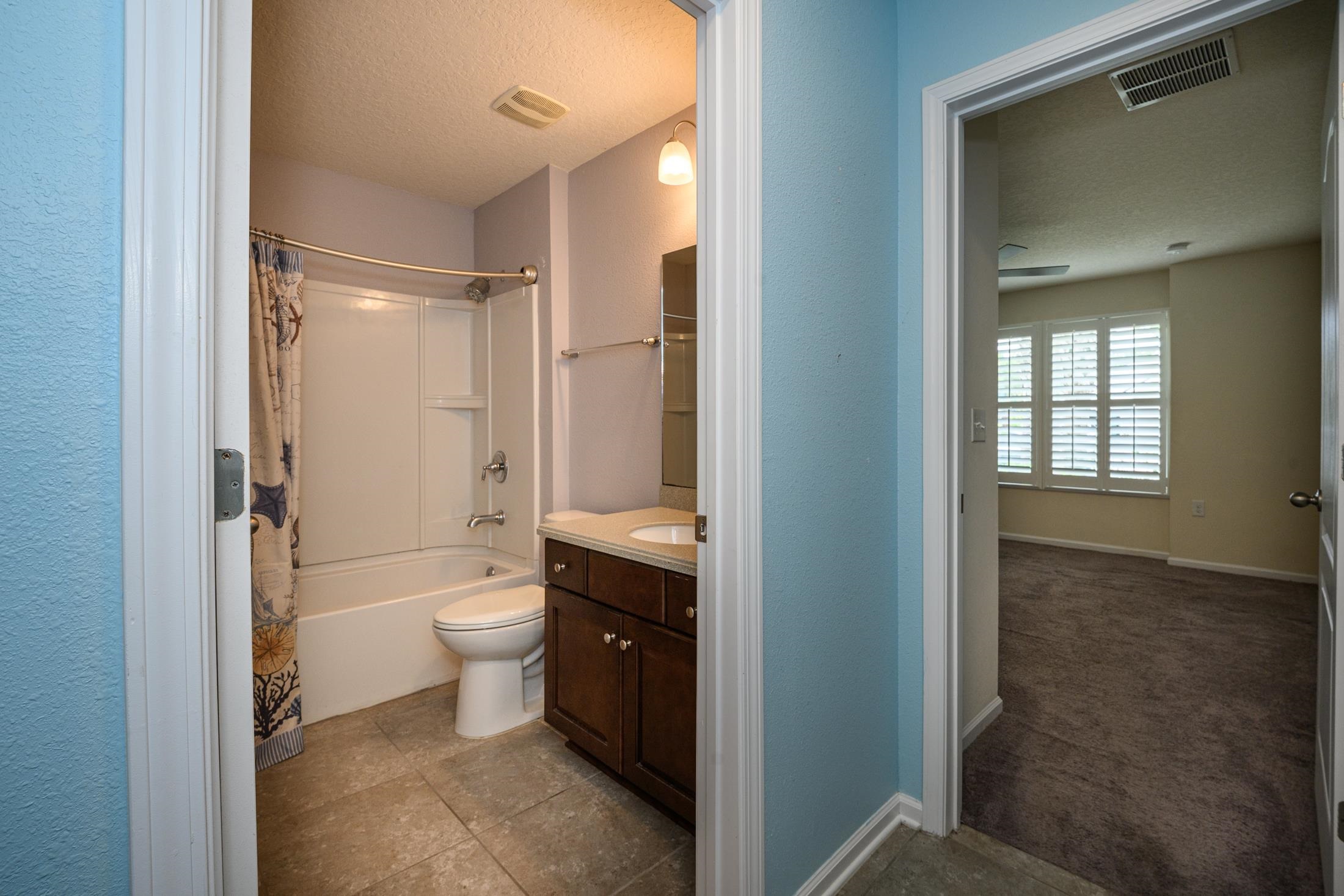 772 Pullman Circle St. Augustine, FL 32084 - Photo 29 of 77 a bathroom with a granite countertop toilet a sink and a mirror