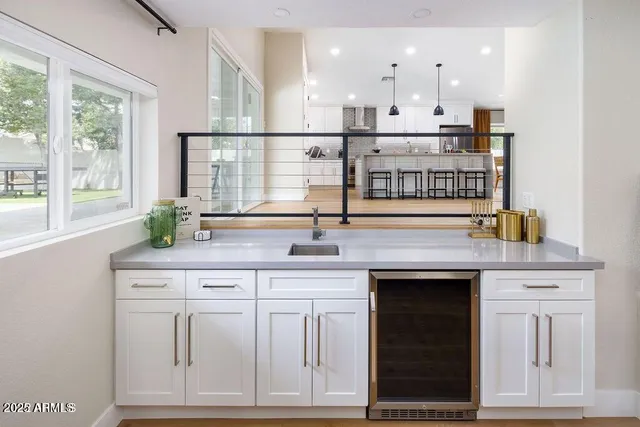 a open kitchen with granite countertop a sink and white cabinets