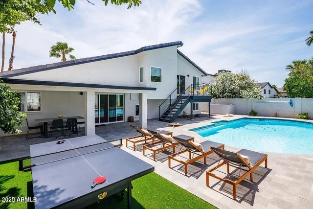 a view of a house with backyard and sitting area
