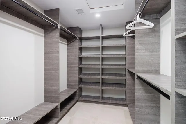 a view of walk in closet with empty racks