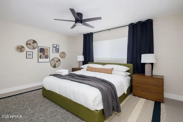 a bedroom with a bed and a lamp on dresser