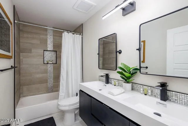 a bathroom with a double vanity sink toilet and shower