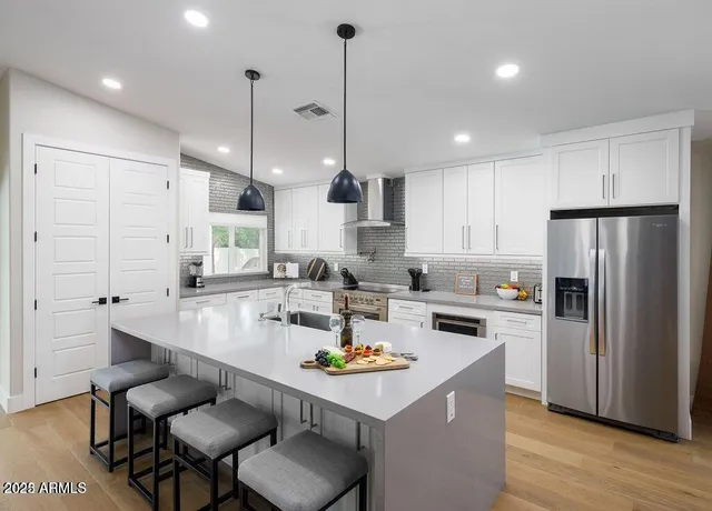a kitchen with refrigerator and chairs