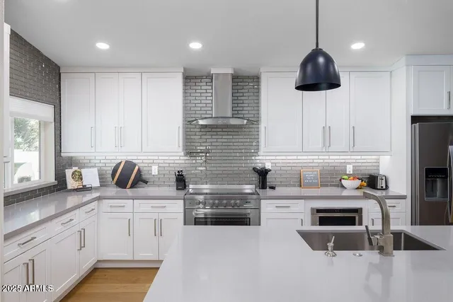 a kitchen with stainless steel appliances a stove a sink a microwave and cabinets