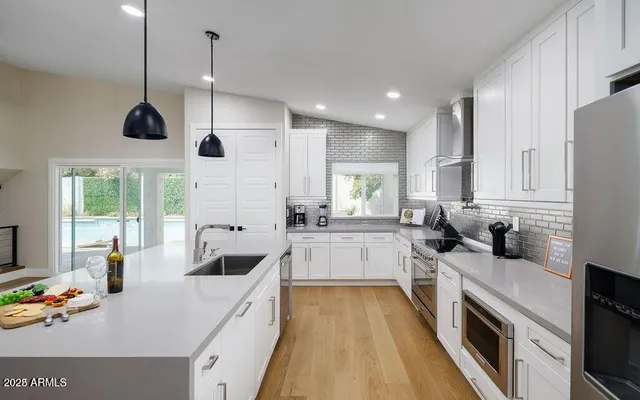 a large kitchen with stainless steel appliances lots of counter space and windows