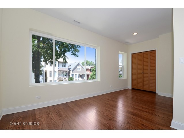3323 North Troy Street Chicago, IL 60618 - Photo 11 of 25 a view of an empty room with wooden floor and a window