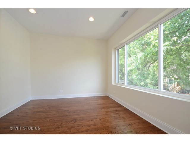 3323 North Troy Street Chicago, IL 60618 - Photo 12 of 25 a view of an empty room with wooden floor and a window