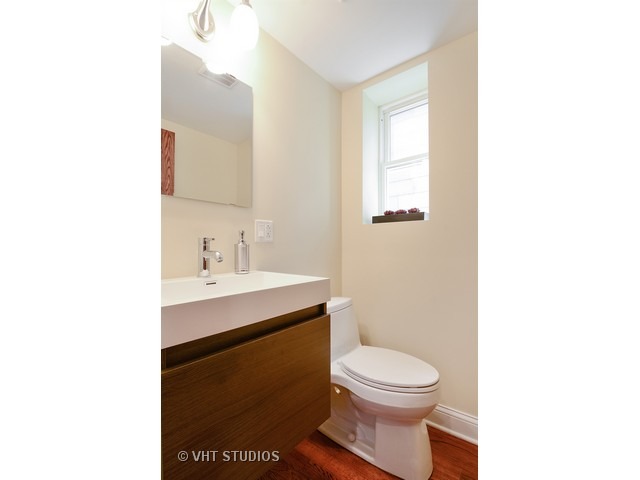 3323 North Troy Street Chicago, IL 60618 - Photo 19 of 25 a bathroom with a toilet a sink a mirror and a window