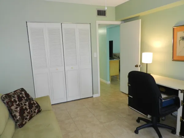 a view of a workspace with furniture and a window