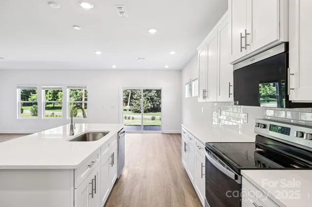 a kitchen with stainless steel appliances kitchen island granite countertop a stove a sink and a microwave