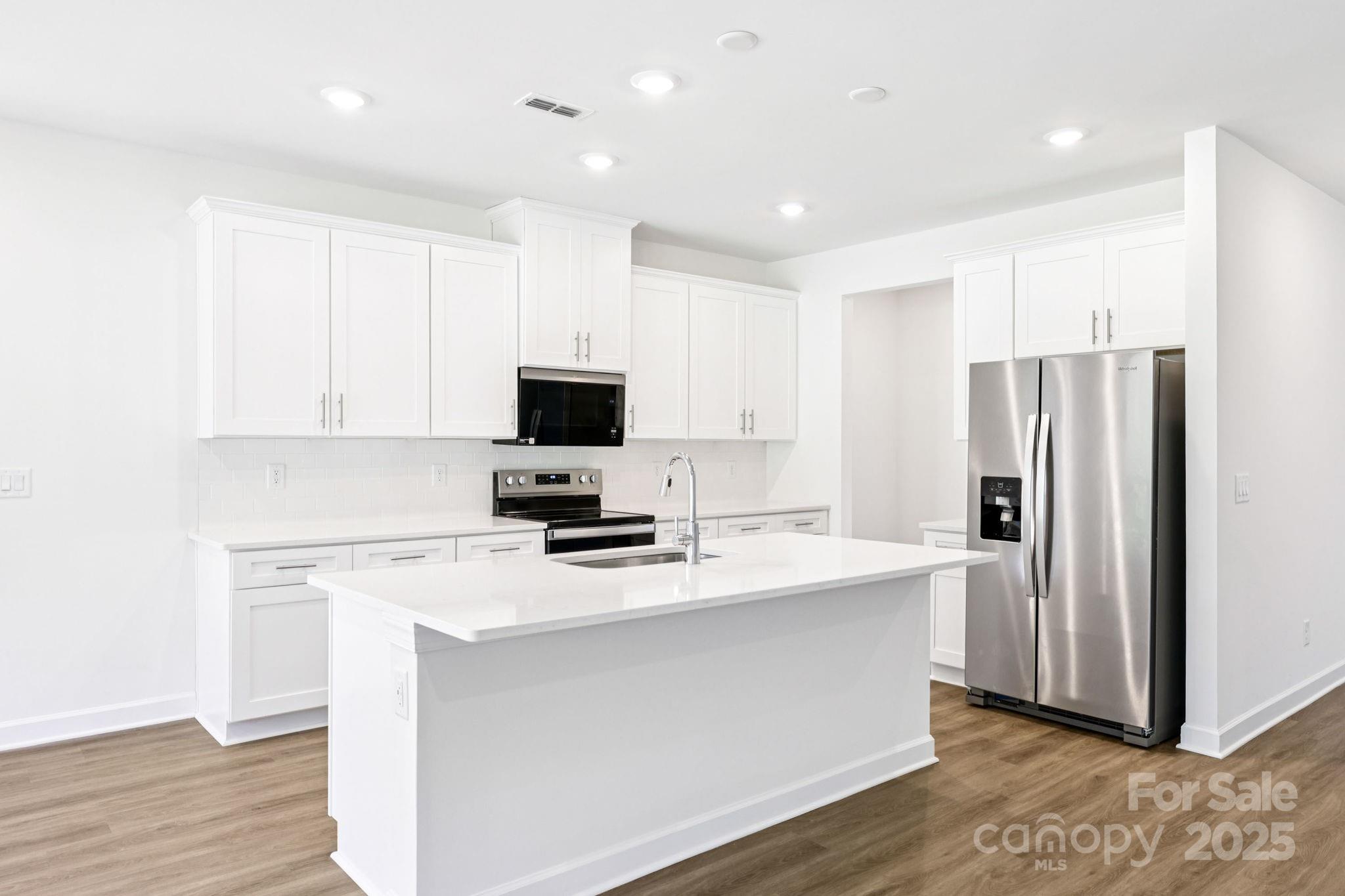 161 Murphy Mdw Road Mocksville, NC 27028 - Photo 8 of 29 a kitchen with a refrigerator sink and white cabinets