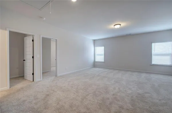 an empty room with windows and closet