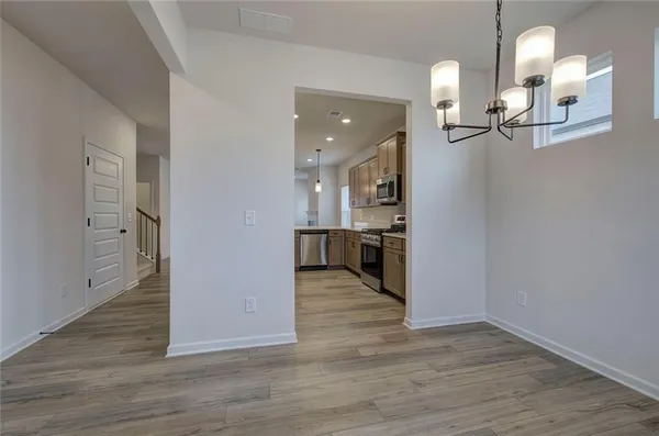 a view of a kitchen and an entryway with wooden floor