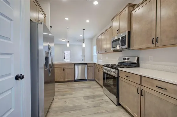 a large kitchen with stainless steel appliances granite countertop a stove a sink and a refrigerator