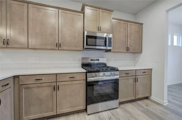 a kitchen with granite countertop white cabinets and stainless steel appliances