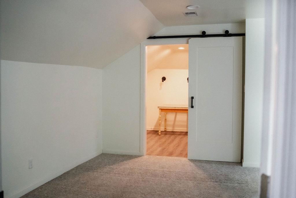 1925 Nelson Avenue Memphis, TN 38104 - Photo 32 of 39 Bonus room that leads into additional space through a barn door, vaulted ceiling, and carpet flooring