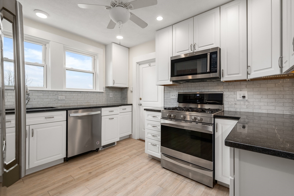 a kitchen with stainless steel appliances granite countertop a stove a microwave and a sink