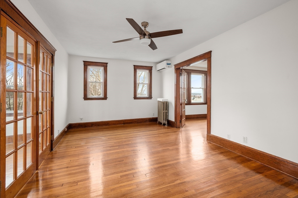 27 Union Street, Unit 3 Boston, MA 02135 - Photo 13 of 28 a view of an empty room with a window and wooden floor